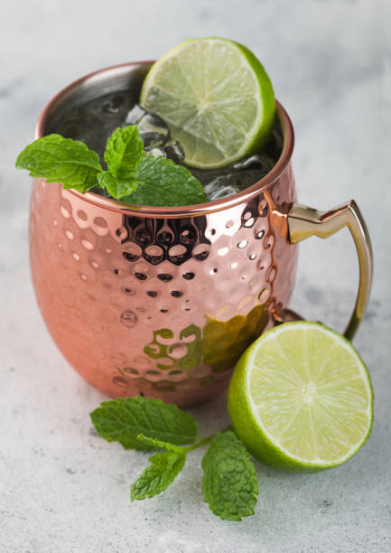istock Moscow mule cocktail in a copper mug with lime and mint on light background 1402602855