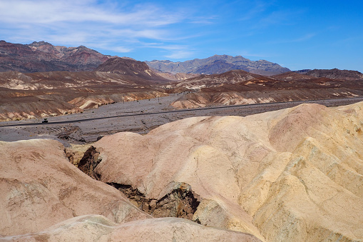 View from Zabriskie Point in Amargosa range in the Death Valley National Park, California, USA. Steaming hot sunny day in the hottest place on Earth. Colorful desert landscape.