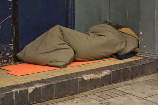 Reading, Berkshire, England, April 8th. 2024: Homeless person sleeping rough outside the Entrance to a warehouse