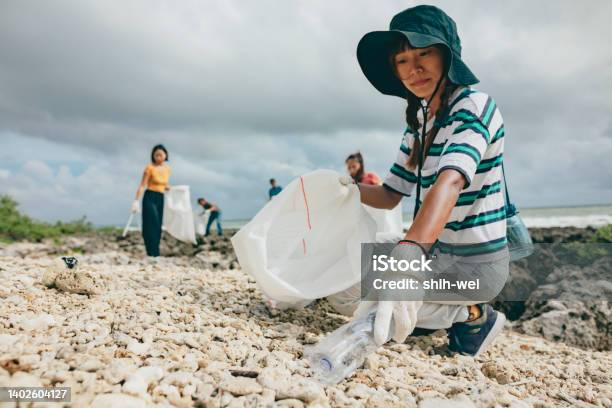Community Volunteer Groups On The Beach Stock Photo - Download Image Now - Chinese Ethnicity, Garbage Bag, Volunteer