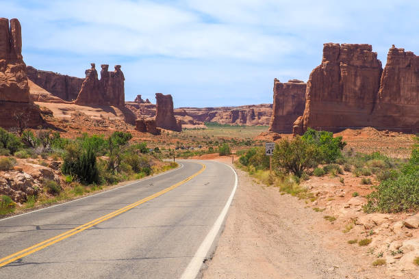 three gossips and courthouse towers rocks in the arches national park, utah, on a beautiful sunny day of spring. road winding through scenic utah desert. driving in the american southwest. - desert the gossips sand rock imagens e fotografias de stock