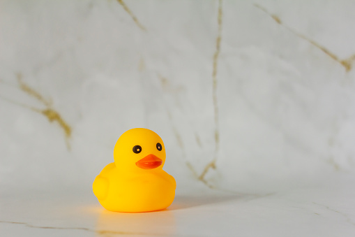 Yellow rubber duck for swimming on a marble background