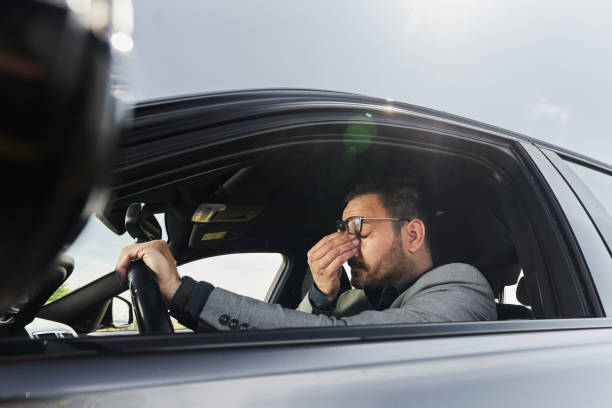 istock Tired businessman driving a car. 1402614161