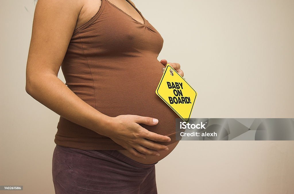 Baby on Board! Heavily pregnant woman ready with her ""Baby on Board"" sign. Baby On Board Stock Photo