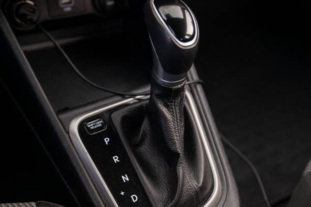 istock Automatic shift gear knob in the passenger compartment of the car in black for driving and acceleration. Abstract image of fast speed. Warranty and recall of transmission by dealer 1402617536