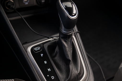 Automatic shift gear knob in the passenger compartment of the car in black for driving and acceleration. Abstract image of fast speed. Warranty and recall of transmission by dealer.