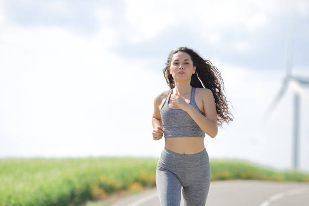 runner woman running in a road in a mill farm - run of the mill imagens e fotografias de stock