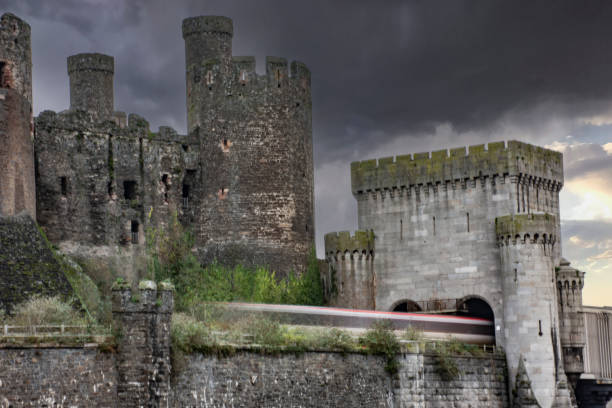 Conwy Castle A train emerges from the tubular bridge over the River Conwy below Conwy Castle, conwy castle stock pictures, royalty-free photos & images