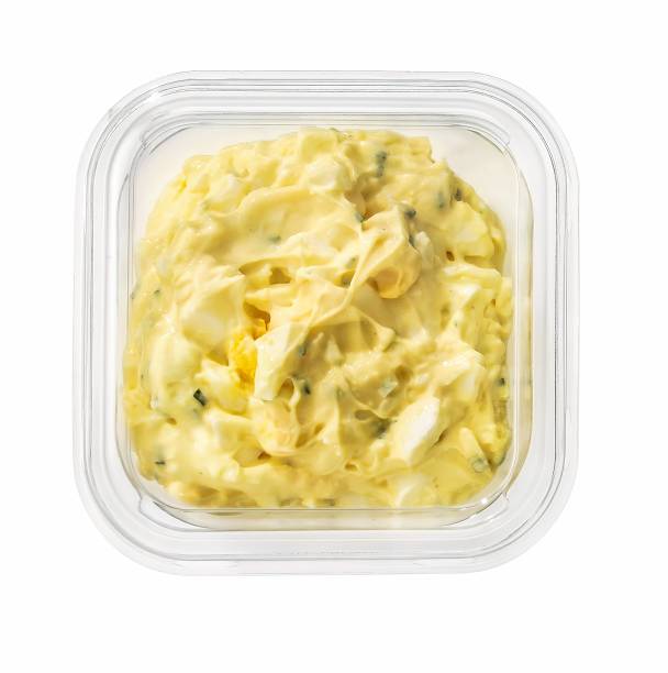 egg spread in a plastic container isolated on white stock photo