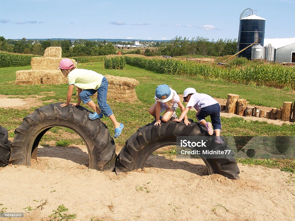 Enfants d'escalade sur tracteur pneus - Photo de Ferme - Aménagement de l'espace libre de droits