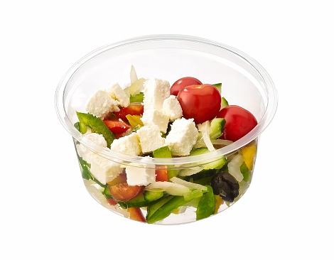 greek salad with fetta in plastic container, isolated on white