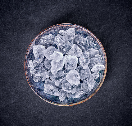 Ice cubes in bowl isolated on black background.