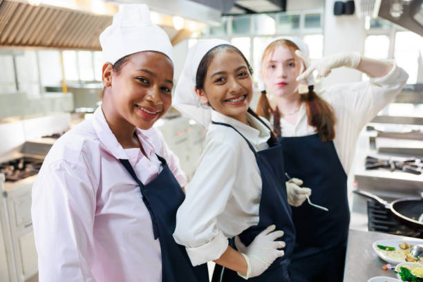 istock Group portrait young wman cooking student. Cooking class. culinary classroom. group of happy young woman multi - ethnic students are focusing on cooking lessons in a cooking school. 1402628183