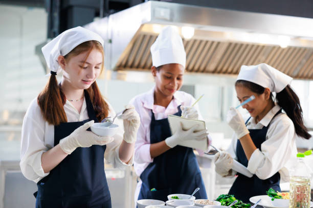 istock take note on book. Cooking class. culinary classroom. group of happy young woman multi-ethnic students are focusing on cooking lessons in a cooking school. 1402628523