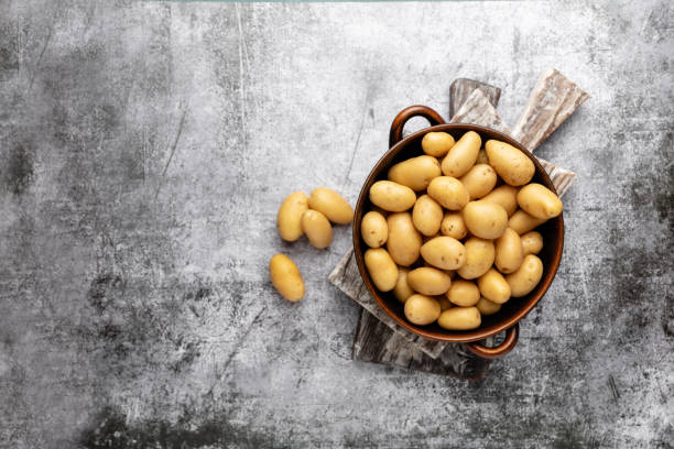 istock Raw small potatoes in a cast iron skillet on a beton background. 1402629762