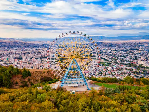 Ferris or Giant wheel aerial panoramic view in Mtatsminda Park of Tbilisi. Tbilisi is the capital and the largest city of Georgia on the Kura River.