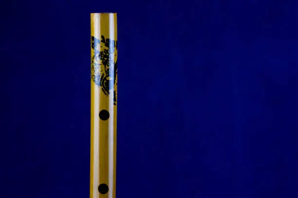 Closeup view of chinese bamboo flute isolated on a blue background