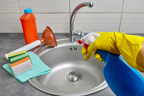 istock Hands in yellow rubber gloves hold a spray bottle with cleaning agent 1402635675