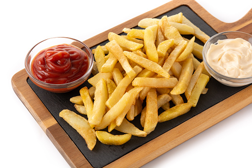 From above of heap of delicious crunchy French fries stacked on black background