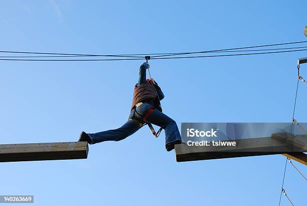 Mujer Tomando Un Salto Peligroso Foto de stock y más banco de imágenes de Cuerda de alambre - Cuerda de alambre, Protección, Accesorio de cabeza