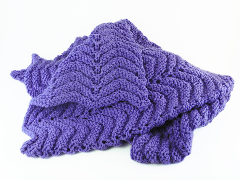 A purple hand-crochet baby blanket on a white background.