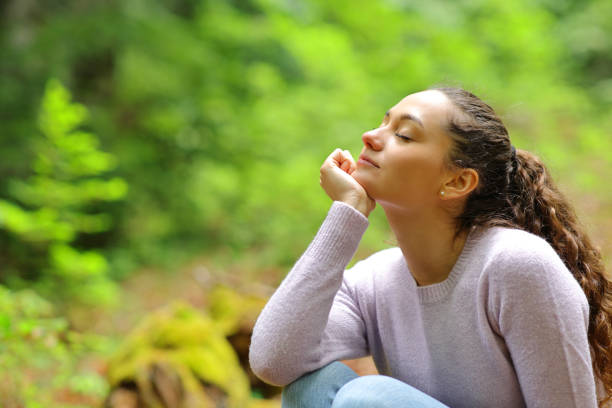 Relaxed woman in a beautiful green forest stock photo