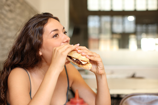Woman eating sandwich in a coffee shop