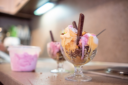 Home made ice cream - Melba with white, pink and orange ice cream, biscuits and chocolate sticks.