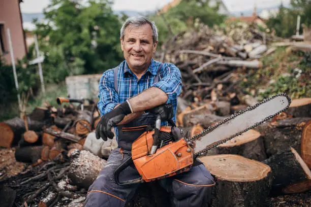 Portrait of a smiling lumberjack with a chainsaw