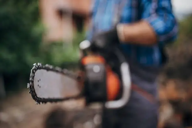 Chainsaw in human hands, close up