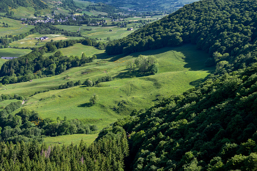 Picturesque landscape of the Auvergne mountains in the Cantal department with meadows, forests and mountains made up of ancient volcanoes