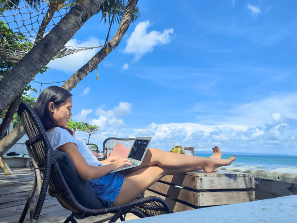 istock Young Asian Woman Working at Seaside Cafe 1402646554