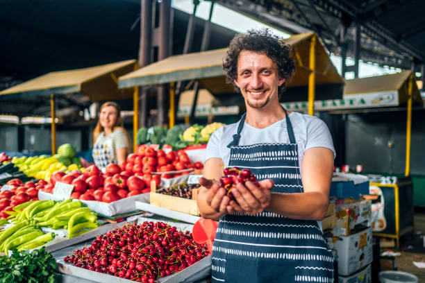istock Seller man offering cherries to a customer 1402646871