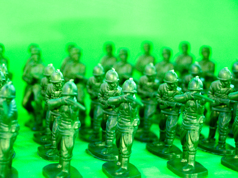 A bunch of green army men on a white background.
