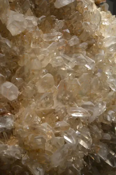 Large cluster of clear crystal quartz stones growing together in a group.