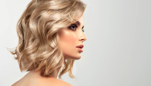 Portrait of woman with hairstyle dyed in metallic blonde color. Hairstyling, dye of hair and makeup. stock photo