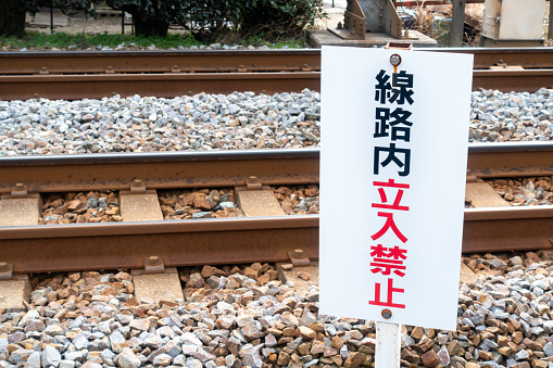 A photo of a sign that prohibits entry to the railroad tracks.