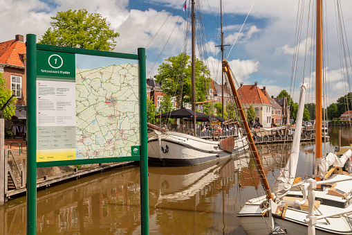 Dokkum, The Netherlands - June 1, 2022: Tourist bicycle route information sign in the ancient Dutch city center of Dokkum, The Netherlands