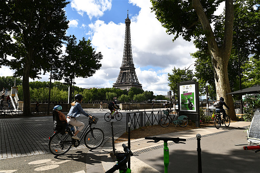 Paris, France-06 06 2022: Cyclists on a cycle path on a Parisian street passing not far from the Eiffel tower, France.