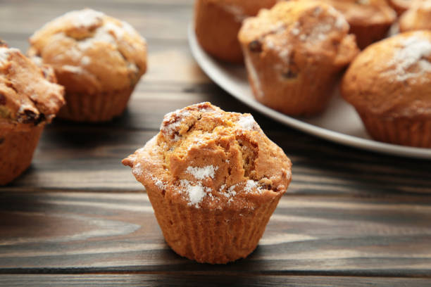 istock Vanilla muffins. Sweet cupcakes on brown background. 1402652082