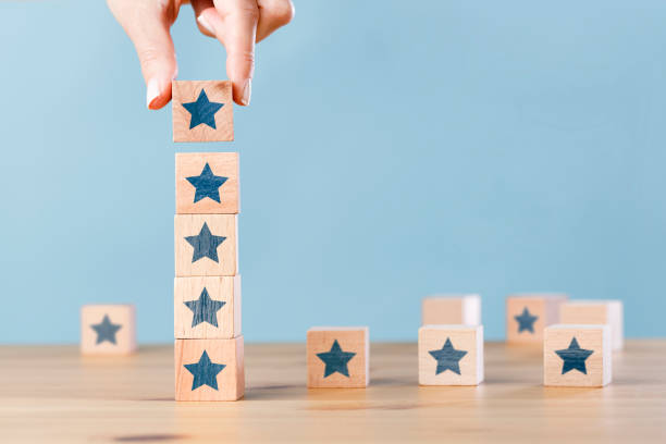 istock Woman hand building wood block cubes stacking on top with star shape. Customer experience concept 1402652240