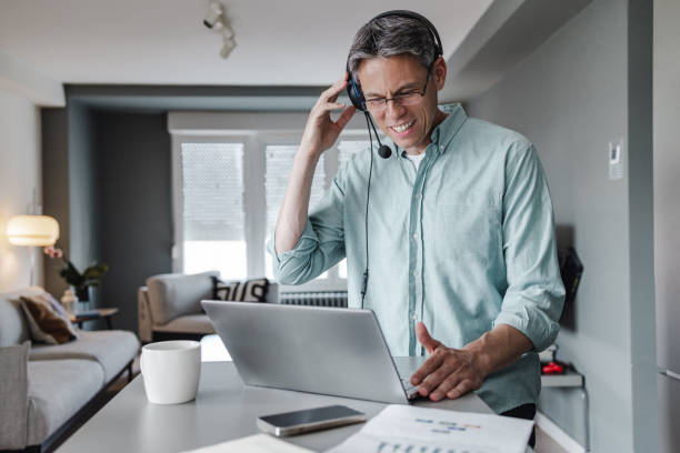 istock Mature businessman communicating on a video call with colleagues and while working at home 1402653783
