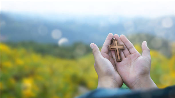 человек молится с крестом в природе восхода фона, символ веры. - praying human hand worshipper wood стоковые фото и изображения