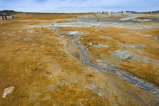 Flow of sulphate from bubbling boiling mud pit natural springs in Hverir Geothermal Field, Iceland