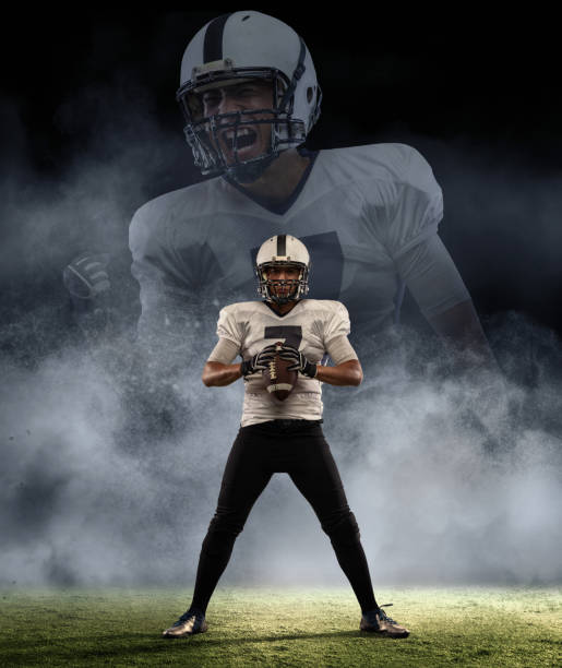 creative portrait of young man, american football player at stadium in motion over smoked background with reflection effect. sport, challenge, goals, activity concept. - football player american football sports team teamwork imagens e fotografias de stock