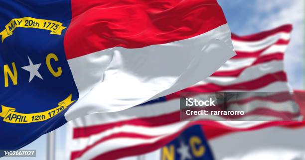 The North Carolina State Flag Waving Along With The National Flag Of The United States Of America Stock Photo - Download Image Now
