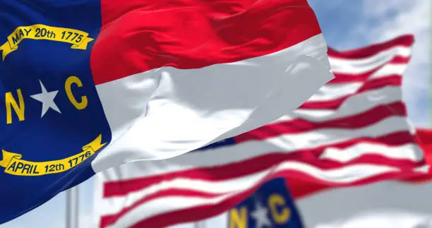 Photo of The North Carolina state flag waving along with the national flag of the United States of America