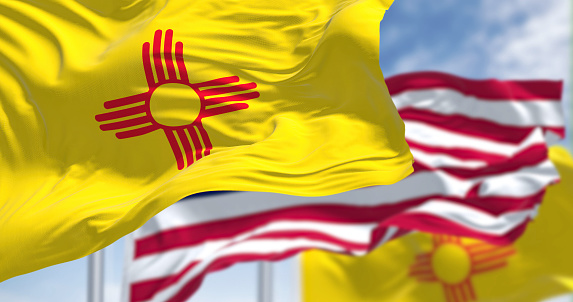 The New Mexico state flag waving along with the national flag of the United States of America