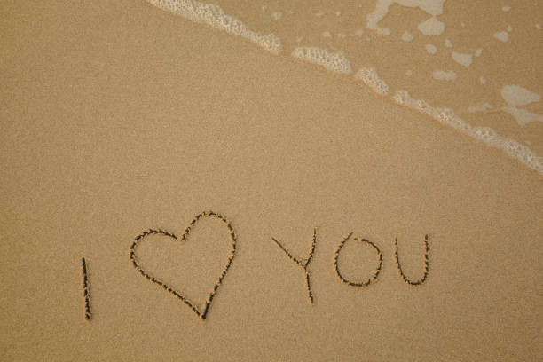 istock I love You - handwritten on the soft beach sand. 1402667619