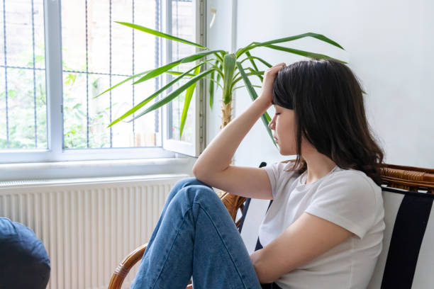 istock Pensive woman in front of the window 1402667639